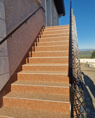 Escalier extérieur recouvert d'un revêtement de sol en résine à granulats orangés, réalisé par CMG LYON